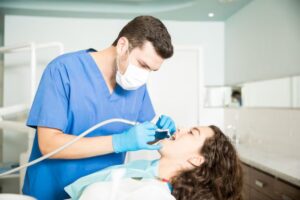 a dentist examines a woman for a tooth filling treatment.