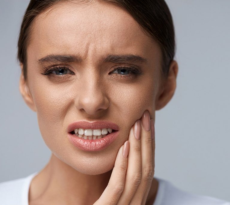 a girl is having pain on her teeth